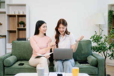 İki kadın sıcak bir oturma odasında uzaktan çalışmaktan zevk alıyor. Kahve içip sohbet ederken dizüstü bilgisayar kullanıyorlar. Serbest, modern yaşam tarzının mükemmel bir karışımı.