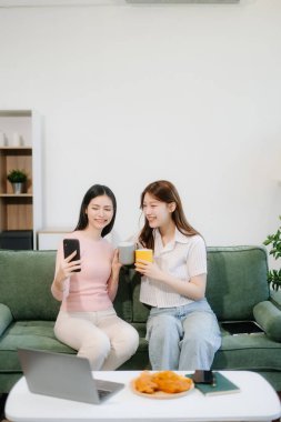 İki kadın sıcak bir oturma odasında uzaktan kumandalı çalışmaktan zevk alıyor. Kahve içip sohbet ederken akıllı telefon kullanıyorlar. Serbest, modern yaşam tarzının mükemmel bir karışımı. 