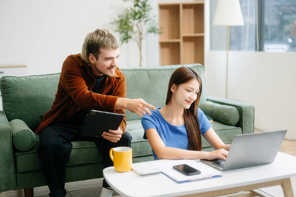 мужчина и женщина наслаждаются удаленной работой в уютной гостиной, используя ноутбук во время чата. фрилансер, современный образ жизни   