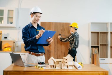 Mimarlar ve mühendisler bir mimarlık ofisinde bir yapı modeli, tasarım, planlama ve yaratıcılık üzerinde işbirliği yaparlar.