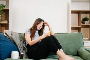 Kanepede çok sayıda hapla oturan genç Asyalı kadın depresyondaki kadın aşırı doz ve depresyon konseptiyle kendini öldürmek istiyor.