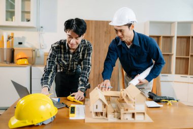 Mimarlar ve mühendisler bir mimari ofiste dizüstü bilgisayar kullanarak bir yapı modeli tasarlayarak, planlayarak ve yaratıcılıkla işbirliği yaparlar. 