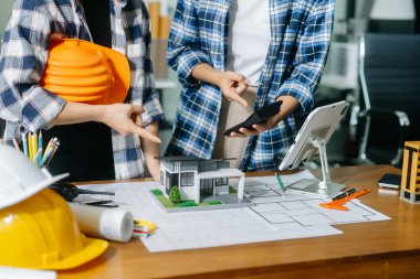 Mühendis Takım Çalışması Toplantısı, Çizim Şirket Ofisi 'ndeki model binasında ortakla birlikte çalışarak proje planı toplantısı üzerinde çalışıyor. Asya endüstrisi profesyonel çayı