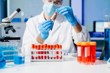 Modern tıbbi araştırma laboratuvarı. Erkek bilim adamı mikro pipetlerle çalışıyor. Biyokimyasal örnekleri analiz ediyor. Gelişmiş tıp kimya laboratuvarı..