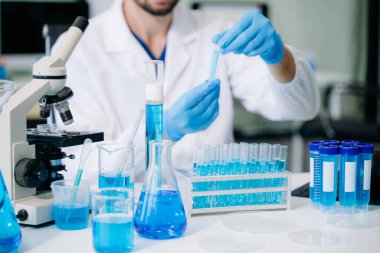 Modern tıbbi araştırma laboratuvarı. Erkek bilim adamı mikro pipetlerle çalışıyor. Biyokimyasal örnekleri analiz ediyor. Gelişmiş tıp kimya laboratuvarı..