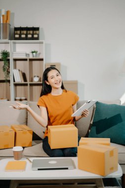 Küçük işletme girişimcisi KOBİ 'de çalışan serbest çalışan kadın ofis, BOX, tablet ve laptop çevrimiçi, pazarlama, paketleme, dağıtım, e-ticaret konsepti
