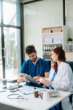 Doktorlar klinikteki hastanın sonuçlarını ya da teşhisini inceliyor. Hastanedeki mobil cihaz üzerinde tartışma ve araştırma yapan ekip çalışması, tıbbi ve sağlık çalışanları