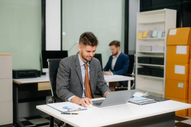Ofis masasında mali analiz üzerinde çalışan kendine güvenen bir iş adamı. İş, muhasebe ve profesyonel iş yeri kavramları için mükemmel.                   