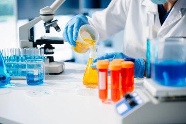 Kadın araştırmacı kimya laboratuvarında bir deney yürütüyor.