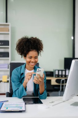 Young beautiful woman using laptop and tablet while sitting at her working place. Concentrated at work.