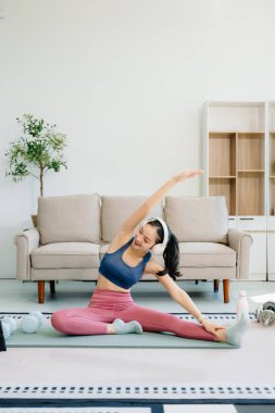 Asyalı Kadın Yoga Yapıyor ve Evde Oturma Odasında Eğitim, Tablette Online Ders İzliyor