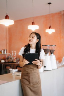 Başlangıçta kafede tabletle çalışan başarılı küçük işletme sahibi kadın.