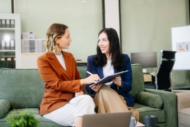 İki iş kadını şık bir ofis ortamında çalışıyor. Takım çalışması, liderlik ve yaratıcılık kavramları için mükemmel..