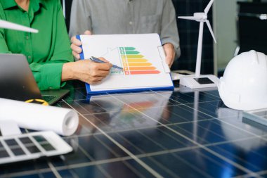 Mühendisler güneş ve rüzgar enerjisi, sürdürülebilirlik, yenilik ve temiz teknolojik çözümler üzerinde işbirliği yaparlar. Takım çalışması, yeşil güç ve gelecek vizyonu..