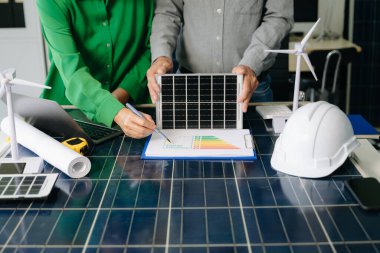 İki mühendis güneş ve rüzgar enerjisi üzerinde işbirliği yaparak, temiz yenilik ve sürdürülebilirlik sağlıyorlar. Takım çalışması, teknoloji ve daha yeşil bir gelecek vizyonu..