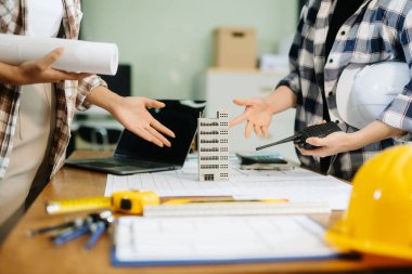 Mühendis Takım Çalışması Toplantısı, Çizim Şirket Ofisi 'ndeki model binasında ortakla birlikte çalışarak proje planı toplantısı üzerinde çalışıyor. Asya endüstrisi profesyonel çayı