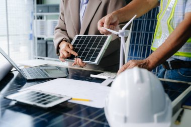 İki mühendis güneş ve rüzgar enerjisi üzerinde işbirliği yaparak, temiz yenilik ve sürdürülebilirlik sağlıyorlar. Takım çalışması, teknoloji ve daha yeşil bir gelecek vizyonu..