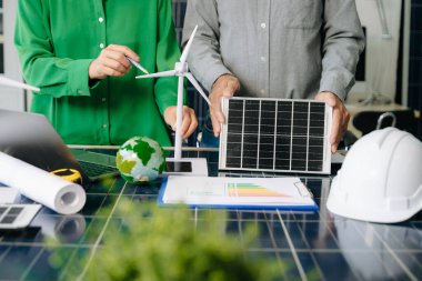 İki mühendis güneş ve rüzgar enerjisi üzerinde işbirliği yaparak, temiz yenilik ve sürdürülebilirlik sağlıyorlar. Takım çalışması, teknoloji ve daha yeşil bir gelecek vizyonu..