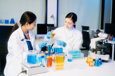 Genç Asyalı bilim adamları bir tıp laboratuarında araştırma yapıyor.