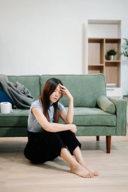 Asyalı kadın Buhran 'da oturur. Koyu saçlı, dalgın bakışlı. Pencere ve anksiyete dolu. Hastalık, sağlık ve iyileşme kavramı.