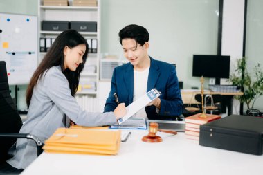 İş adamları, modern ofisteki sözleşme belgeleriyle iş birliği yapmaktadır..