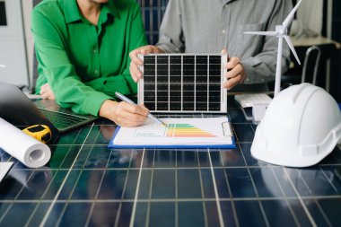 İki mühendis güneş ve rüzgar enerjisi üzerinde işbirliği yaparak, temiz yenilik ve sürdürülebilirlik sağlıyorlar. Takım çalışması, teknoloji ve daha yeşil bir gelecek vizyonu..