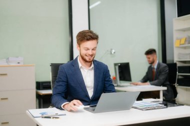 Ofiste dizüstü bilgisayarla çalışan profesyonel bir iş adamı. İş, finans, muhasebe ve işyeri kavramları için mükemmel. 