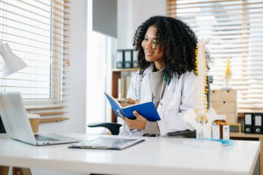 Sağlık uzmanı diz anatomisini açıklıyor. Tıbbi bir ortamda bir model kullanarak, tıbbi danışmanlık ve hasta bakımını vurguluyor.