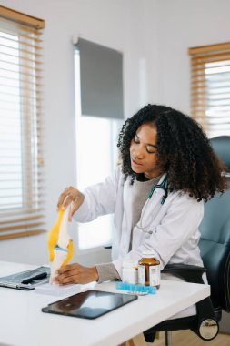 Sağlık uzmanı diz anatomisini açıklıyor. Tıbbi bir ortamda bir model kullanarak, tıbbi danışmanlık ve hasta bakımını vurguluyor.