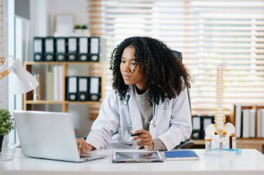 Sağlık uzmanı diz anatomisini açıklıyor. Tıbbi bir ortamda bir model kullanarak, tıbbi danışmanlık ve hasta bakımını vurguluyor.