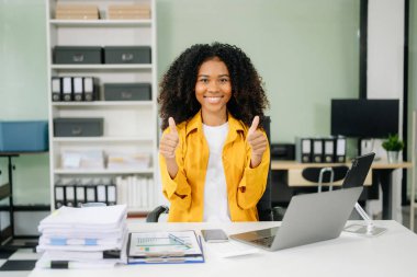 Çalışan not defteri, tablet ve dizüstü bilgisayarla çalışan genç iş kadını akıllı telefon, tablet ve dizüstü bilgisayarla konuşuyor. Video arama vergisi, rapor, muhasebe 
