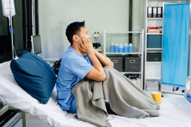 Endişeli hasta hastane yatağında oturuyor, tıbbi bakım, iyileşme ve sağlık hizmetlerine bağlı duyguları yakalıyor.