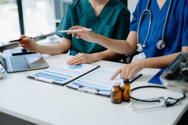 Tıp teknolojisi ekip toplantısı konsepti. Doktor El, akıllı telefon, modern dijital tablet ve grafik arayüzü olan dizüstü bilgisayarla çalışıyor., 