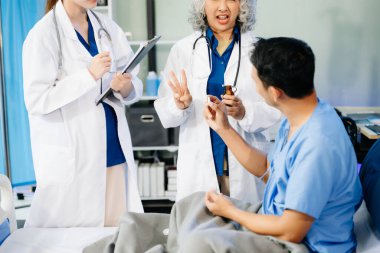 Profesyonel Asyalı doktorlar hastalarla konuşur, sağlık tavsiyesi verir, modern hastanede gelişmiş ekipmanlarla tedavi planı önerirler. 