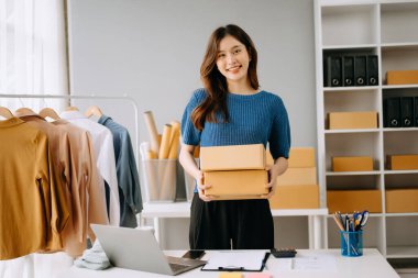 Küçük işletme girişimcisi KOBİ 'de çalışan serbest çalışan kadın ofis, BOX, tablet ve laptop çevrimiçi, pazarlama, paketleme, dağıtım, e-ticaret konsepti