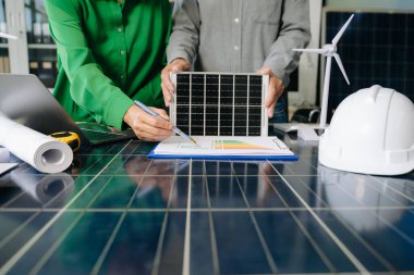 Mühendisler güneş ve rüzgar enerjisi, sürdürülebilirlik, yenilik ve temiz teknolojik çözümler üzerinde işbirliği yaparlar. Takım çalışması, yeşil güç ve gelecek vizyonu..