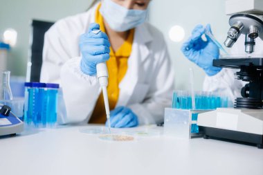 Laboratuar önlüklü bilim adamları, cam eşyalar üzerinde araştırma yapıyorlar ve modern, yüksek teknoloji laboratuvarında kimyasallarla çalışıyorlar..