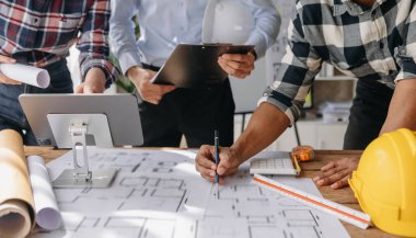 Birlikte çalışan mühendis ekipleri, modern kentteki inşaat sahasına işçi kaskı takıyorlar.