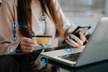 Tablet, dizüstü bilgisayar kullanan ve kredi kartlı cep telefonunu internet bankacılığı ödeme iletişim ağı, internet kablosuz uygulama simgeleri kullanan bir kadın 