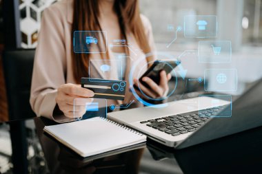 Tablet, dizüstü bilgisayar kullanan ve kredi kartlı cep telefonunu internet bankacılığı ödeme iletişim ağı, internet kablosuz uygulama simgeleri kullanan bir kadın