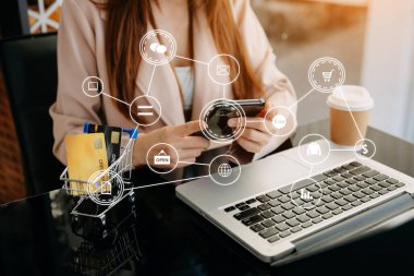 Tablet, dizüstü bilgisayar kullanan ve kredi kartlı cep telefonunu internet bankacılığı ödeme iletişim ağı, internet kablosuz uygulama simgeleri kullanan bir kadın 