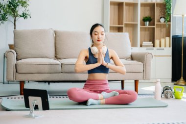 Asyalı Kadın Yoga Yapıyor ve Evde Oturma Odasında Eğitim, Tablette Online Ders İzliyor