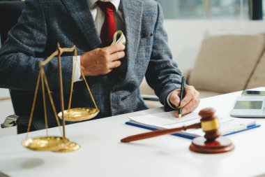 Adalet ve hukuk kavramı: Mahkeme salonunda sözleşme belgeleri ve parayla çalışan bir erkek yargıç
