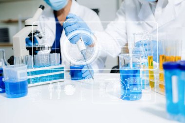 Modern tıbbi araştırma laboratuvarı. Kadın bilim adamı elleri mikro pipetlerle çalışıyor. Biyokimyasal örnekleri analiz ediyorlar. Gelişmiş kimya laboratuvarı. 