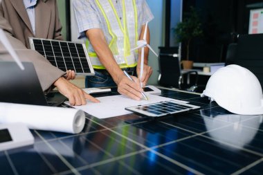 İki mühendis güneş ve rüzgar enerjisi üzerinde işbirliği yaparak, temiz yenilik ve sürdürülebilirlik sağlıyorlar. Takım çalışması, teknoloji ve daha yeşil bir gelecek vizyonu..