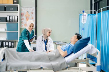 Hastane koğuşundaki bir hastayla ilgilenen doktorlar takım çalışması, profesyonellik ve sağlık hizmetleri sergiliyor.