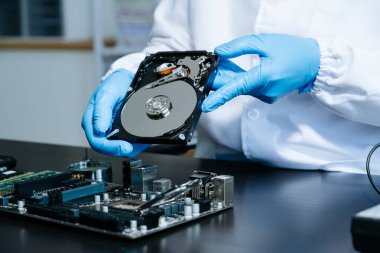  Teknisyenin masasında sabit disk ve bir bilgisayar ana kartı var. Veri, donanım ve bilgi teknolojisi kavramı