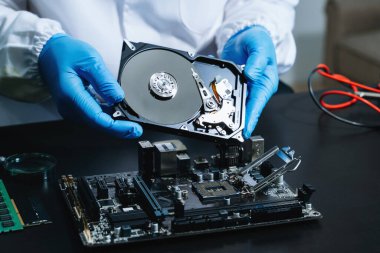  Teknisyenin masasında sabit disk ve bir bilgisayar ana kartı var. Veri, donanım ve bilgi teknolojisi kavramı