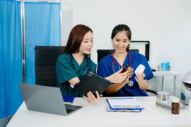 Modern bir ofiste birlikte çalışan Asyalı doktorlar ve hemşireler, klinik bir ortamda sağlık hizmetleri, danışma ve profesyonel bakımı sergilemektedirler..