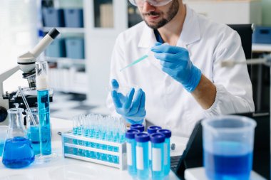 Erkek biyoteknoloji uzmanı yeni kimyasal maddeleri test ediyor. 